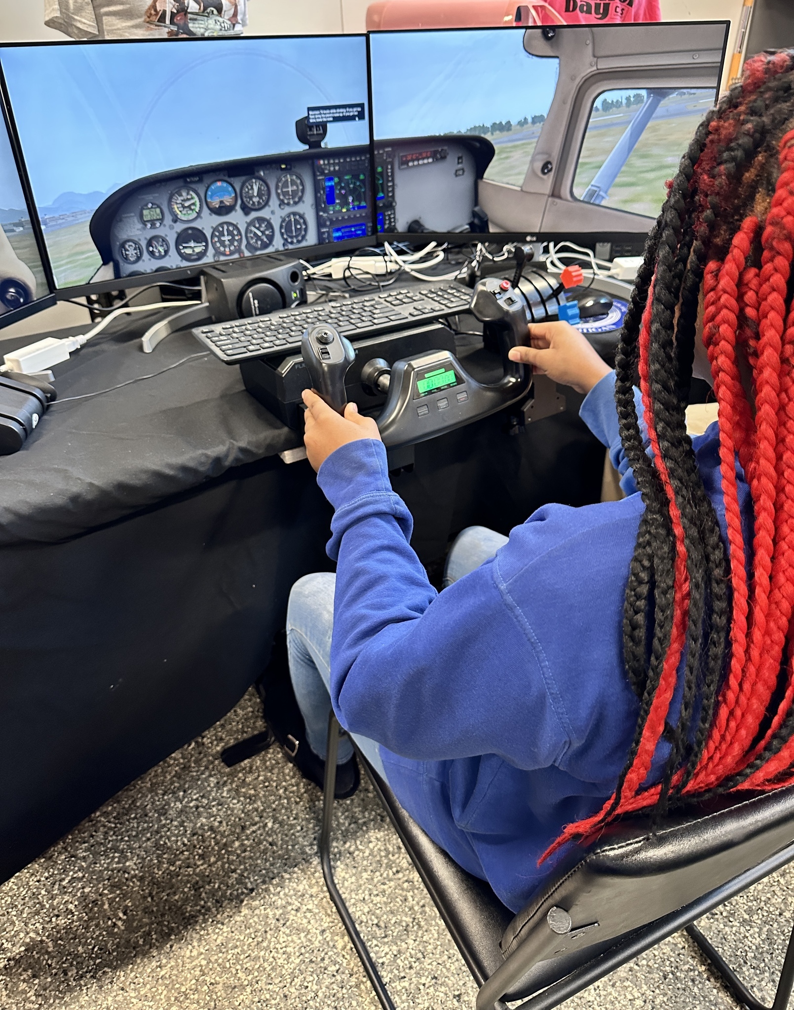 A student tries a flight simulator where she tests being a pilot.